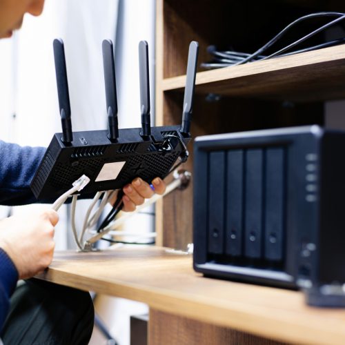 Man Preparing Cables For For Network Attached Storage System, Concept For NAS Usage At Home Or At Small Businesses